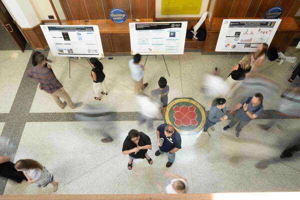 Students and faculty attend a science poster session in a Notre Dame building.